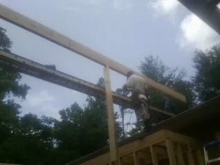 Carpenter setting a ridge beam over a new addition frame — Ice Dam Removal by Roofing Brothers in Herington