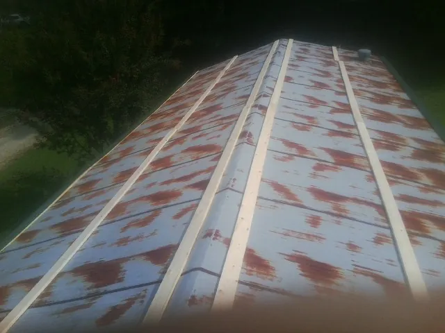 Rusted metal roof panels with new wood purlins before replacement — Storm Damage Roof Repair in Herington by Roofing Brothers