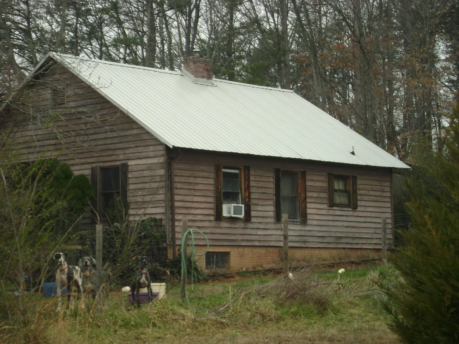 White metal roof on an old wood sided farmhouse, from a Metal Roof Installation job in Herington